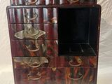 a small wooden cabinet with drawers and a mirror