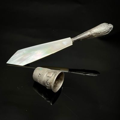 une cuillère en argent et un couteau posés sur une surface noire
