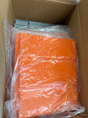 a cardboard box filled with orange sheets of plastic