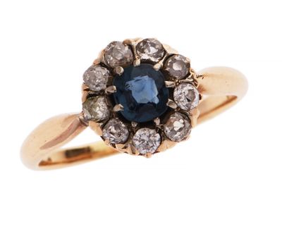 gros plan d'une bague avec un saphir bleu entouré de diamants blancs