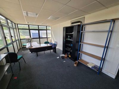 a room with a desk, shelves, and a chair in it