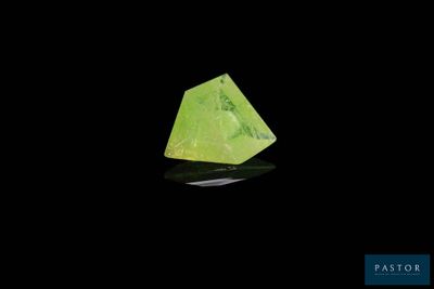 un gros plan d'un cristal vert sur une surface noire