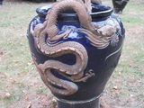 a blue vase with a dragon on it in the grass