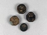 trois petits boutons métalliques posés sur une surface blanche