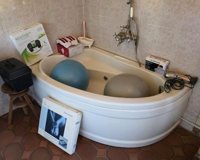a bathtub with a ball in it in a bathroom