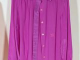 purple shirt hanging on a hanger next to a white wall