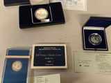 some silver coins are sitting on a table next to other silver coins