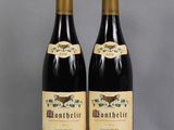 two bottles of wine sitting next to each other on a table