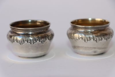deux tasses en argent posées l'une à côté de l'autre sur une table
