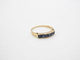 a gold ring with a blue stone in the middle
