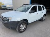 une photo d'une Dacia blanche garée devant un immeuble