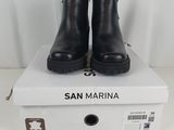 une paire de bottines noires posée sur une boîte blanche
