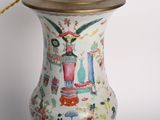 a white vase with a gold handle on a table