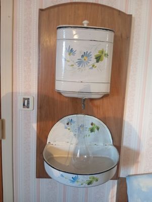 Vue depuis l'entrée d'une salle de bains équipée d'un lavabo et de toilettes
