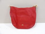 a red coach purse on a white table