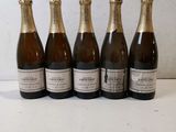 six bottles of champagne lined up in a row on a table