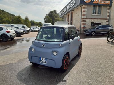 une petite voiture bleue garée devant un immeuble