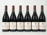 six bouteilles de vin rouge sont alignées sur une table