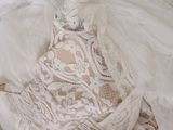 an image of a white wedding dress laying on top of a bed