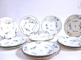 six assiettes ornées de fleurs bleues, posées sur une table blanche