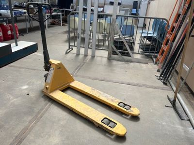 un chariot élévateur posé au sol dans un entrepôt