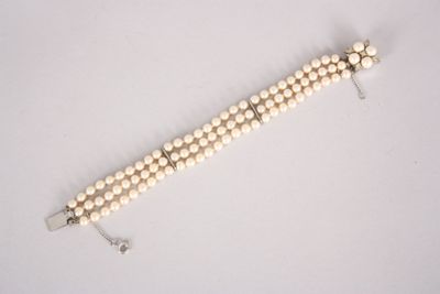 a close up of a white beaded necklace on a white surface