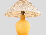 an image of a yellow table lamp with a woven shade on it
