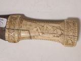 a small carved object on a white surface
