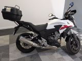 une moto blanche et noire garée sur un sol à damier