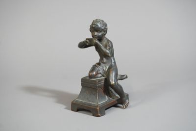 une petite statue représentant un garçon assis sur un tabouret