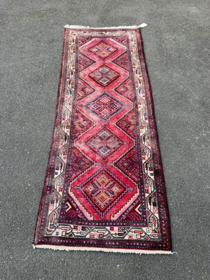 un tapis rouge et rose orné d'un motif en losanges