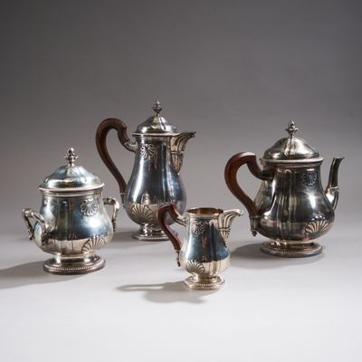 four pieces of silver tea and coffee set on a white surface