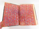 quelqu'un tient un livre ouvert sur lequel figure un motif