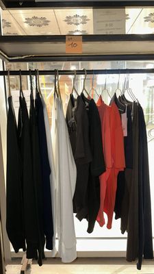 a lot of clothes hanging on a rack in a store