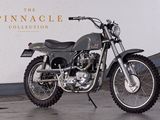 a motorcycle that is parked in front of the pinnacle collection sign