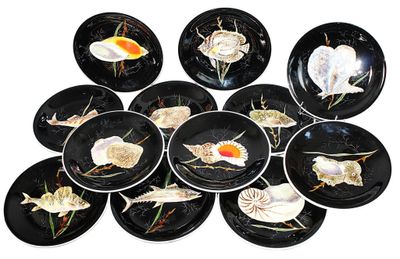 many black plates with shells on them on a white surface