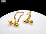 pair of gold plated cufflinks with chain on a white plate