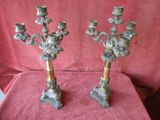 pair of antique brass candelabs on a red cloth