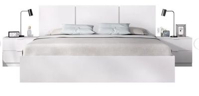 a picture of a bed with a white headboard and night stands