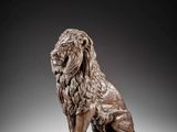 a bronze statue of a lion sitting on a pedestal