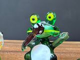 three figurines of a frog and a turtle on a table
