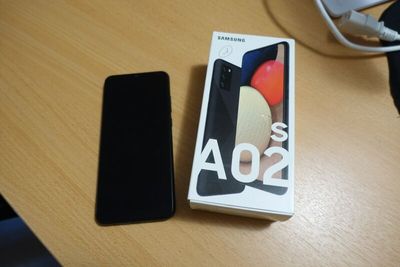 a box with a phone on a table next to a charger