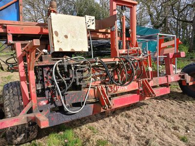 un tracteur qui est à l'arrêt dans la terre, près d'un autre tracteur