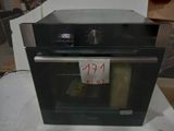 a black oven sitting on a table with a price tag on it