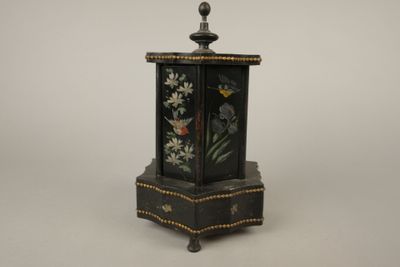 une petite boîte noire décorée de fleurs peintes