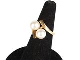 un gros plan d'une bague ornée de deux perles