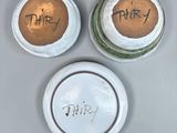 three ceramic jars with writing on them sitting next to each other