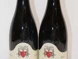 deux bouteilles de vin posées sur une table l'une à côté de l'autre