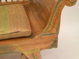 a wooden bench with a green cushion on top of it