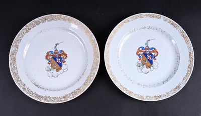 deux assiettes blanches bordées d'or et ornées d'un blason bleu et rouge